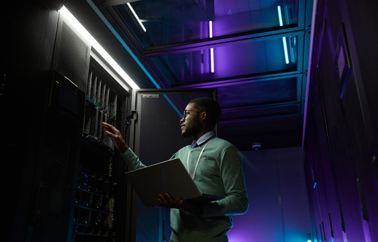 Data center technician in a dark black purple and blue cool environment 