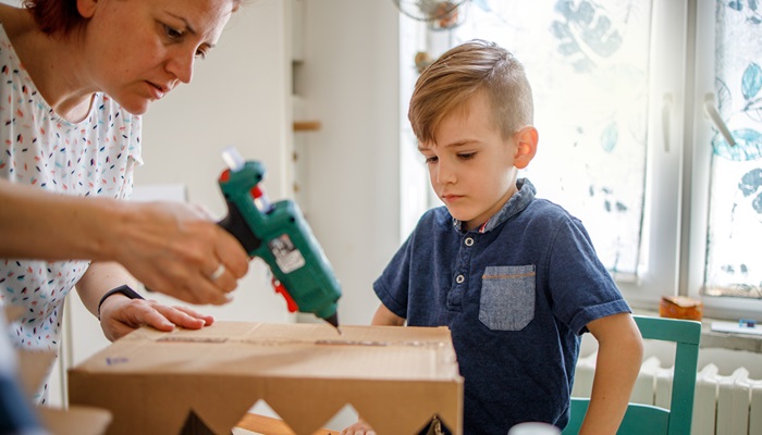 Picture of a mum and a boy pasting a box showcasing adhesion feature for Vistamaxx